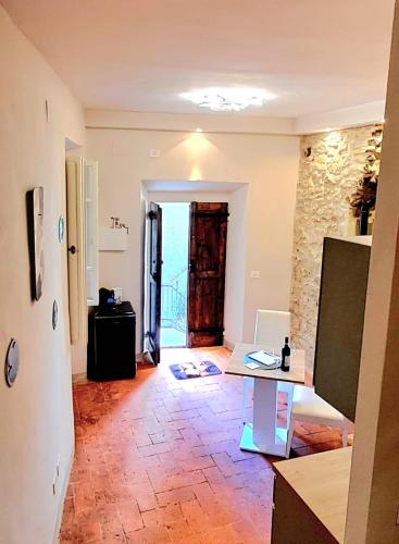 a living room with a table and a stone wall at La Gatta in Montemerano