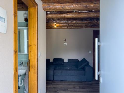a bedroom with a blue couch and a sink at Terrazzo Panoramico - Vicino ad Asiago in Roana