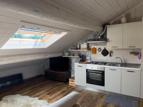 a kitchen with a sink and a stove in a room at Terrazzo Panoramico - Vicino ad Asiago in Roana