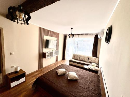 una sala de estar con una cama y un sofá en Historic Center Apartment, en Ruse