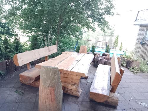 a wooden table and benches on a patio at Nähe Plohn Park - FEWO mit Spielzimmer und Balkon, DZ in Auerbach