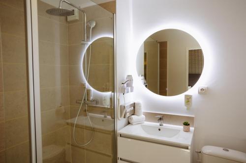 a bathroom with a shower and a sink and a mirror at Clarion Aparthotel Toulouse Le Parc de l'Escale in Toulouse