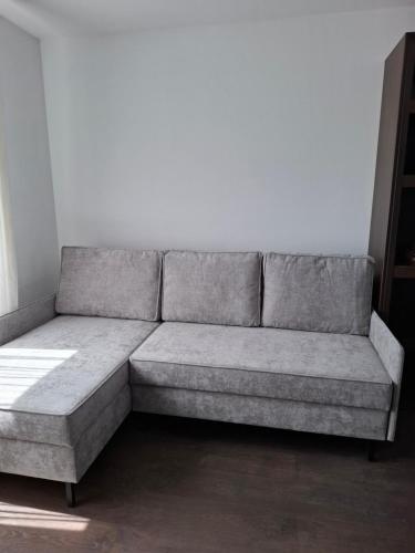 a gray couch sitting in a room at Alma Apartments Starachowice in Starachowice