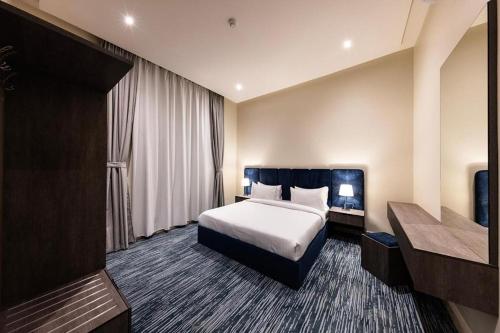 a hotel room with a bed and a desk at Towlan Qurtuba 2 in Riyadh
