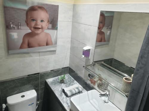 a baby in a bathroom with a mirror at Superb studio at the ocean in Rabat