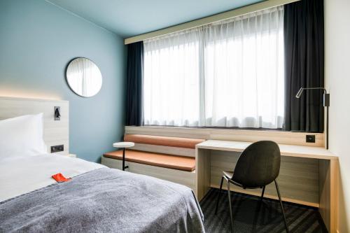 a bedroom with a bed and a desk and a chair at Citybox Brussels in Brussels