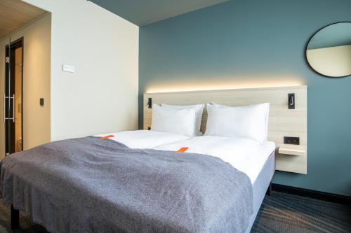 a bedroom with a large white bed with a blue wall at Citybox Brussels in Brussels