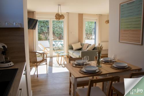 a kitchen and living room with a table and chairs at Logis Robin in Agon Coutainville
