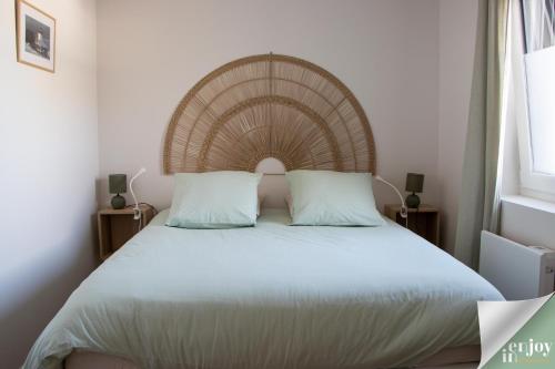 a bedroom with a large bed with a wooden headboard at Logis Robin in Agon Coutainville