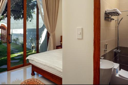 a bedroom with a bed and a bathroom with a sink at Homestay Mai Biển Ninh Chử in Thôn Mỹ Nghĩa