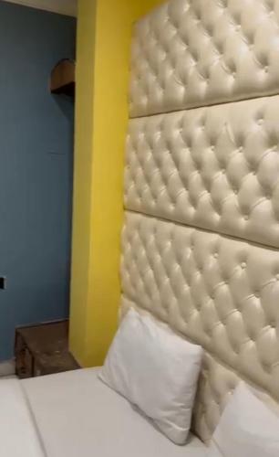 a bed with a white headboard and a pillow at Hotel GP Stays in Kolkata
