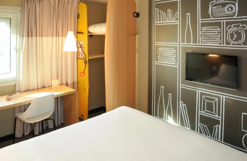 a room with a bed and a desk and a tv at ibis Paris Place d’Italie 13ème in Paris