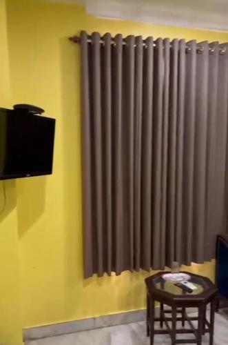 a living room with a window with a gray curtain at Hotel GP Stays in Kolkata
