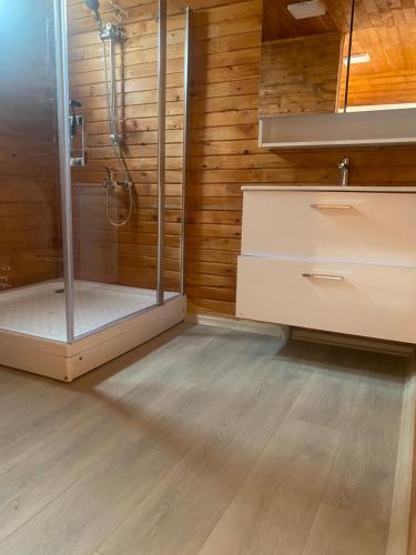 a bathroom with a shower and a wooden wall at Nefesurla Bungalov 5 in Urla