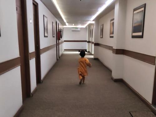 a small child walking down a hallway in a building at Lyallpur Galleria Mall Apartment, 1 BHK, 1 Bedroom with Living Room, Basement Parking, 24x7 Security in Faisalabad