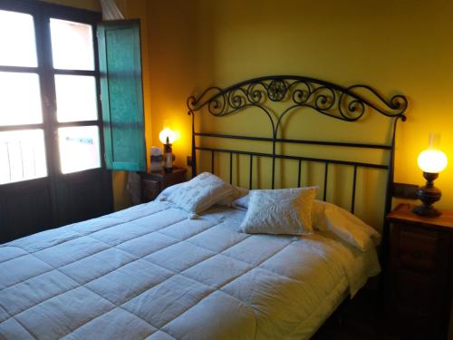 a bedroom with a large white bed with two pillows at Carpe Diem in Navaridas