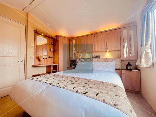 a large white bed in a small room at Vallie Retreats at Tattershall Lakes in Billinghay