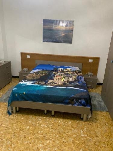 a bed with a blue comforter in a bedroom at Brezza di Mar Ligure - casa vacanza in Borghetto Santo Spirito