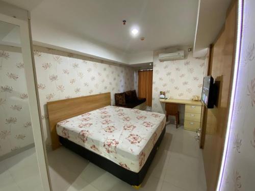 a small bedroom with a bed and a desk at Comfy Studio Room Apartment in Semarang