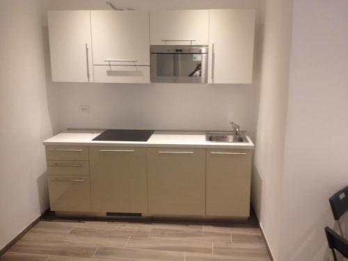 a kitchen with white cabinets and a sink at Residence Fanny in Alassio