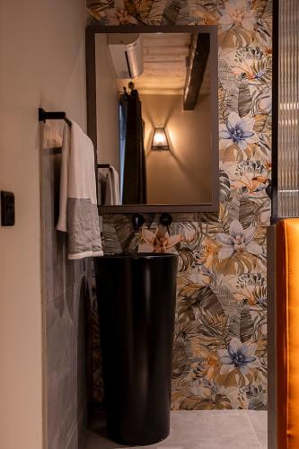 a bathroom with a mirror and a trash can at Zekka House in Valletta