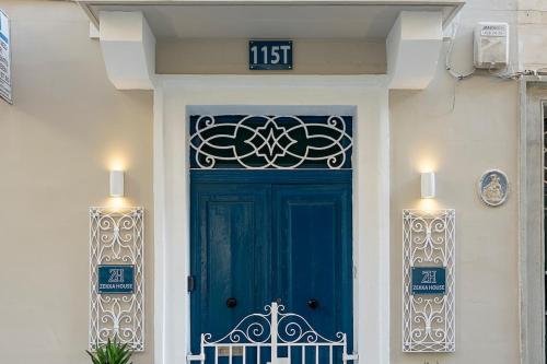 a blue door on a white building with a sign above it at Zekka House in Valletta
