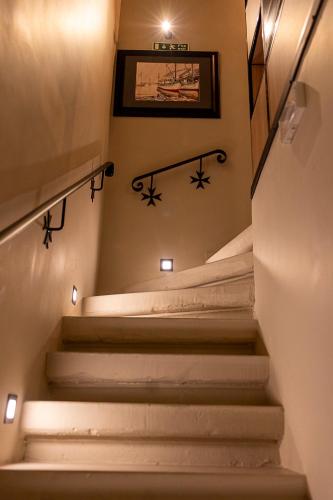 a stairway with white steps and a picture on the wall at Zekka House in Valletta