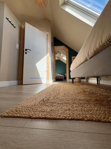 an attic room with a large bed and a door at Fermette Ardennaise typique in Wanlin
