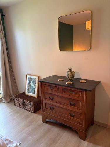 a wooden dresser with a mirror on a wall at Fermette Ardennaise typique in Wanlin