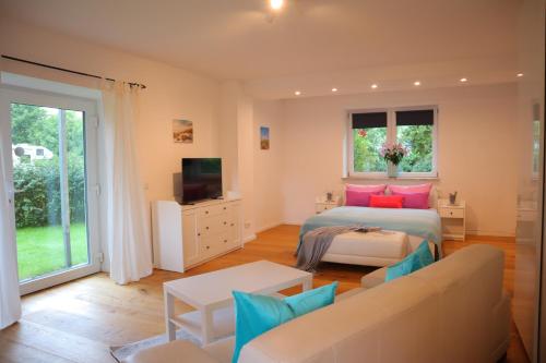 a bedroom with a bed and a couch and a tv at Ferienwohnung Am Deich in Kappeler Niederstrich