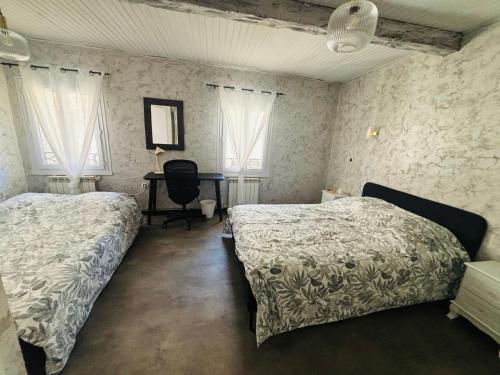 レ・ペンヌ・ミラボーにあるTriplex cosy au cœur du villageのベッドルーム1室(ベッド2台、デスク、窓付)