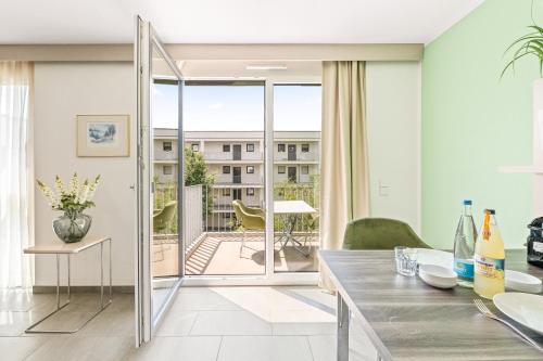 jadalnia z przesuwnymi szklanymi drzwiami prowadzącymi na balkon w obiekcie Meri Boarding Europaplatz w Stuttgarcie