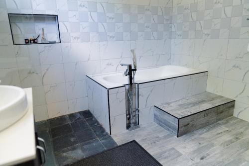 a white bathroom with a sink and a mirror at Villa Soleil de L'est in Port Mathurin