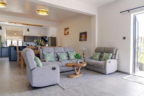 a living room with two couches and a table at Villa Soleil de L'est in Port Mathurin