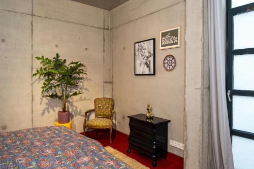a bedroom with a bed and a chair and a plant at Fort Vuren in Vuren