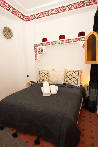 a bedroom with a large bed with two pillows at Riad KASBAH in Tangier