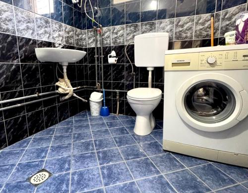 a bathroom with a toilet and a washing machine at Podujeva - Home Sweet Home in Orllan