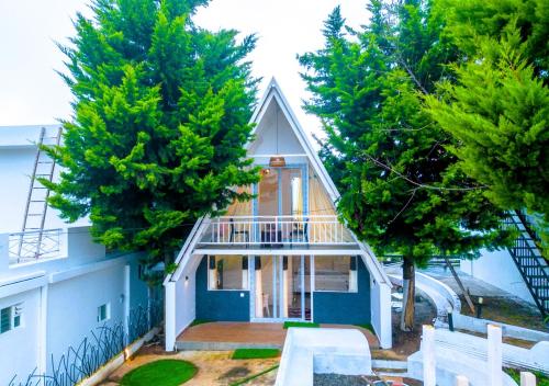 a small house with a balcony and trees at Cucuu Nest Villa Coonoor by VOYE HOMES in Coonoor