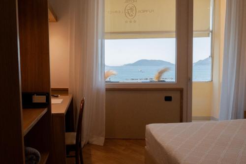a bedroom with a window with a view of the ocean at Hotel Florida Lerici in Lerici