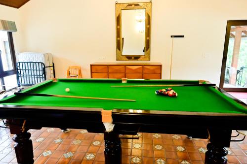 a pool table in a living room with a mirror at Villa Vaasa Luxury Homestay in Avathi