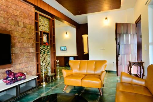 a living room with a couch and a chair at Villa Vaasa Luxury Homestay in Avathi