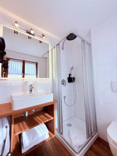 a white bathroom with a shower and a sink at Ferienhaus Rosa 1 & 3 in Füssen