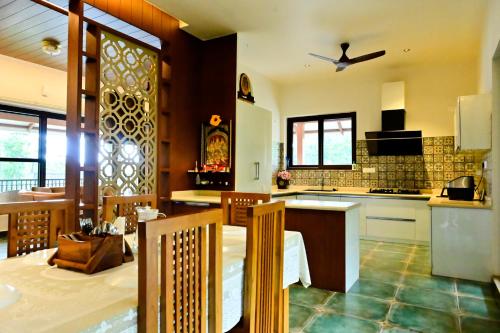 a kitchen with a table and a counter top at Villa Vaasa Luxury Homestay in Avathi