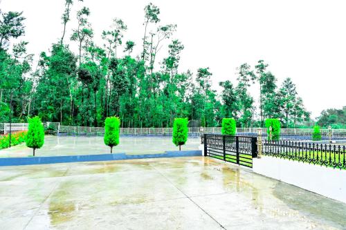 a tennis court with green trees and a fence at Villa Vaasa Luxury Homestay in Avathi