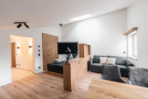 a living room with a couch and a tv at Stadthaus Rosengartenschlucht in Imst