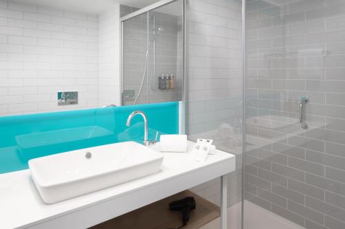 a bathroom with a sink and a shower at Holiday Inn Express & Suites Sion by IHG in Sion