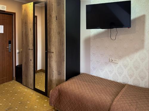 a bedroom with a bed and a flat screen tv on the wall at VitaPark Stariy Dub in Truskavets