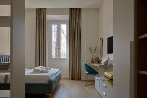 a bedroom with a bed and a desk and a window at Cosmo Lake City Apartments in Como
