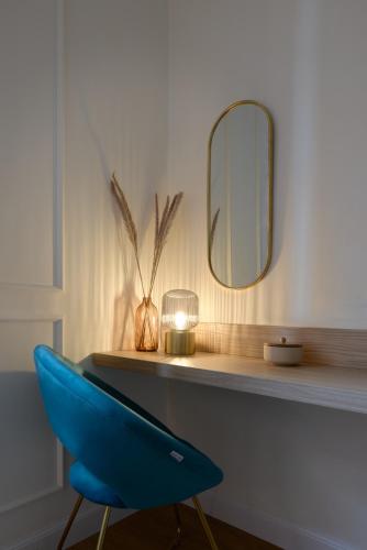 a blue chair sitting on a desk with a mirror at Cosmo Lake City Apartments in Como