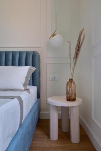a table with a vase on it next to a bed at Cosmo Lake City Apartments in Como